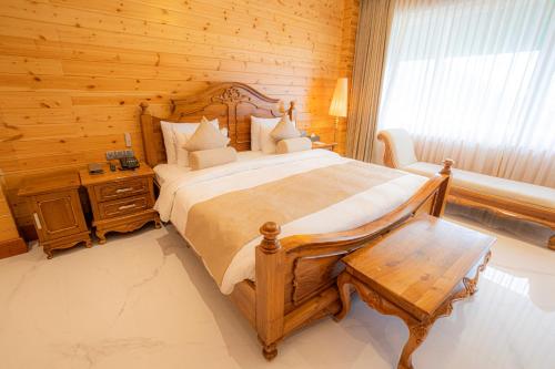 a bedroom with a large bed and a wooden wall at Araliya Red - Budget friendly Hotel- Where you find stunning 360 panoramic view of Nuwara Eliya in Nuwara Eliya