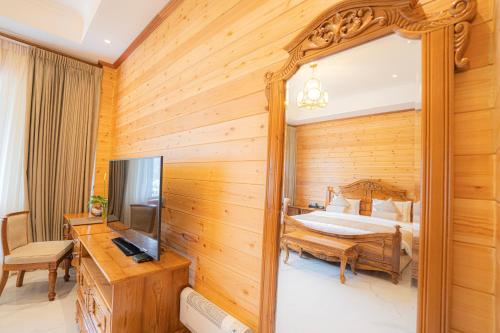 a bedroom with a bed and a television at Araliya Red - Budget friendly Hotel- Where you find stunning 360 panoramic view of Nuwara Eliya in Nuwara Eliya