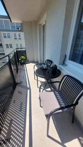 a patio with three chairs and a table on a balcony at Apartman 33 in Kiseljak