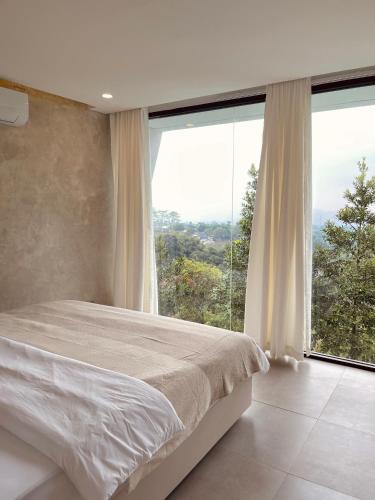 a bedroom with a bed and a large window at Villa Morris By The Villas 100 in Cilama