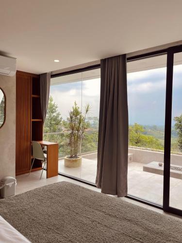 a bedroom with a large glass window with a desk and a desk at Villa Morris By The Villas 100 in Cilama