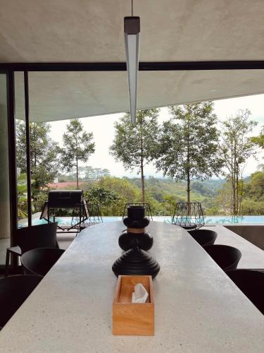 a long table in a room with a view of a pool at Villa Morris By The Villas 100 in Cilama