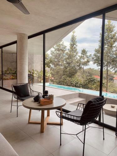 a living room with a table and chairs and a pool at Villa Morris By The Villas 100 in Cilama