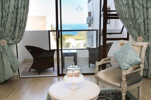 a living room with chairs and a table and a window at Misty Waves Boutique Hotel in Hermanus