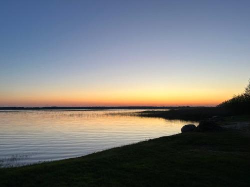 a sunset over a body of water at Tõhela Järve Puhkeküla in Männikuste