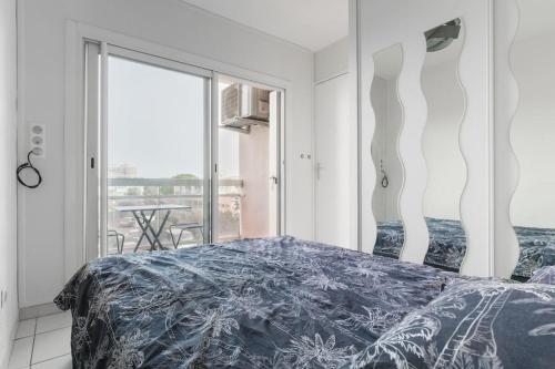 une chambre avec un lit et une grande fenêtre dans l'établissement T2 proche mer et commerces, à Palavas-les-Flots