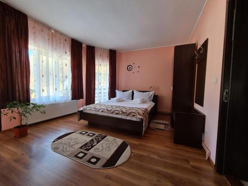 a bedroom with a bed and a rug on the floor at Casa Lizuca in Moieciu de Jos