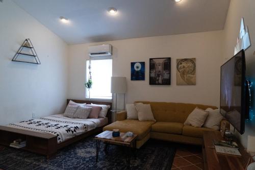 a living room with a couch and a tv at Lofty Dreams B&B, studio near Disney & Universal in Orlando