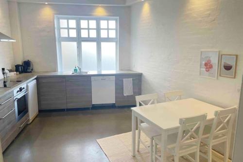 a kitchen with a table and a table and chairs at The old hardware store 3 bedroom in Aalborg