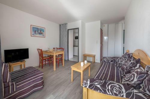 un salon avec un canapé et une table dans l'établissement Appartement pour 4 avec Piscine et Jacuzzi, au Pouliguen