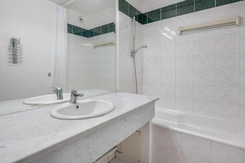 une salle de bain blanche avec un lavabo et une douche dans l'établissement Appartement pour 4 avec Piscine et Jacuzzi, au Pouliguen