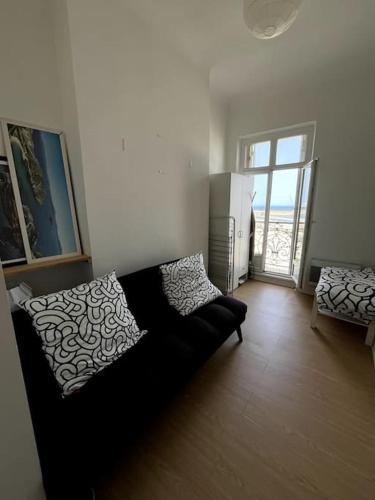 - un salon avec un canapé noir et une fenêtre dans l'établissement Appartement vue sur mer à Marseille, à Marseille