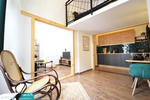 a living room with chairs and a kitchen at Often-Hide Apartment in Częstochowa