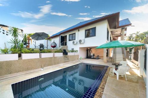 a villa with a swimming pool and a house at Golden Sands Villa only 15 minutes walk to beach in Ban Lum Fuang