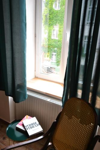 a book sitting on a table next to a window at Often-Hide Apartment in Częstochowa