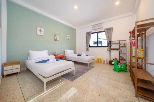 a bedroom with two beds and a book shelf at Golden Sands Villa only 15 minutes walk to beach in Ban Lum Fuang