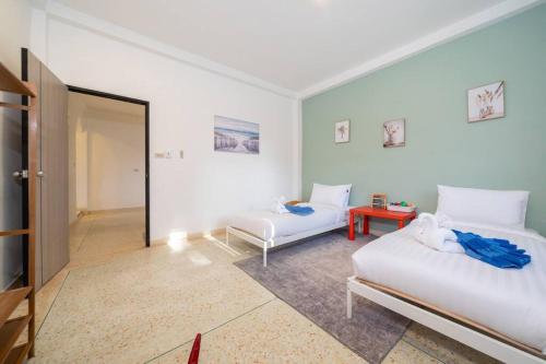 a bedroom with two beds and a door to a room at Golden Sands Villa only 15 minutes walk to beach in Ban Lum Fuang