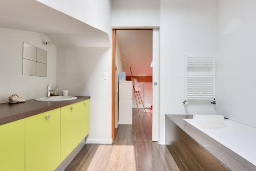 - une cuisine avec des placards jaunes et un évier dans l'établissement 950m plage - Maison architecte 4 adultes - 2enfants, à Andernos-les-Bains