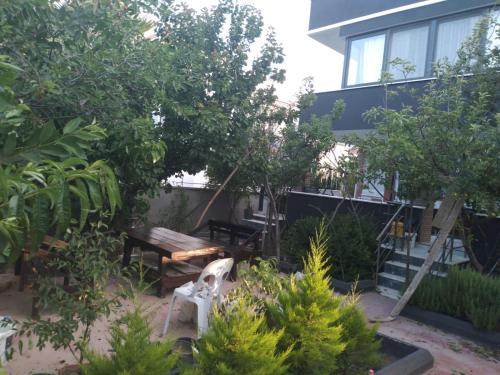 a garden in front of a building with a wooden bench at VESTAS VILLAS in Kusadası