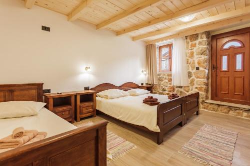 a bedroom with two beds and a stone wall at Villa Stone Valcer in Slivno