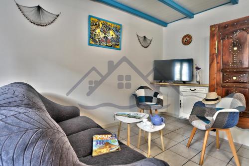 un salon avec un canapé, des chaises et une télévision dans l'établissement LocaLise - M2B - Maison de vacances à la pointe de Lechiagat - Wifi inclus - Draps inclus - Terrain entièrement clos - Maison de plain pied, à Tréffiagat