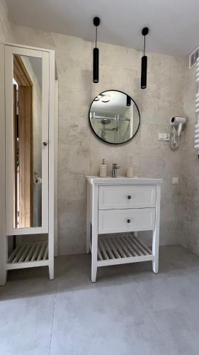 a bathroom with a white sink and a mirror at Kraken-pokoje gościnne in Krynica Morska