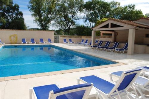 - une piscine avec des chaises longues dans l'établissement Le Cabanon T1 à Quissac, résidence avec piscine, à Quissac
