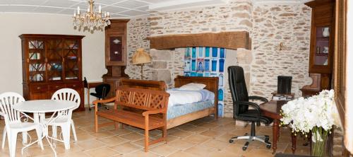 une chambre avec un lit, une table et des chaises dans l'établissement Maison de maître de 1789 rénovée avec piscine, à Roannes-Saint-Mary