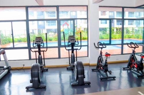a gym with several exercise bikes in a room with windows at JKIA Sky Suite in Nairobi