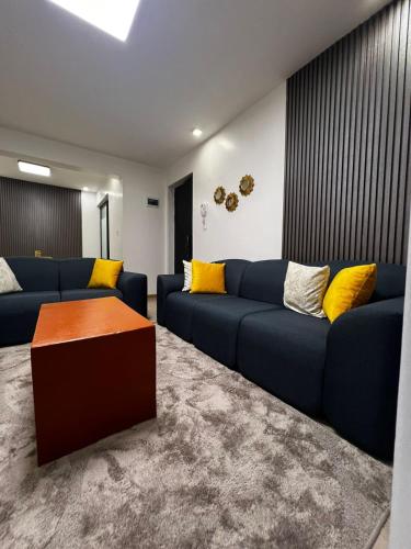 a living room with a blue couch and yellow pillows at JKIA Sky Suite in Nairobi