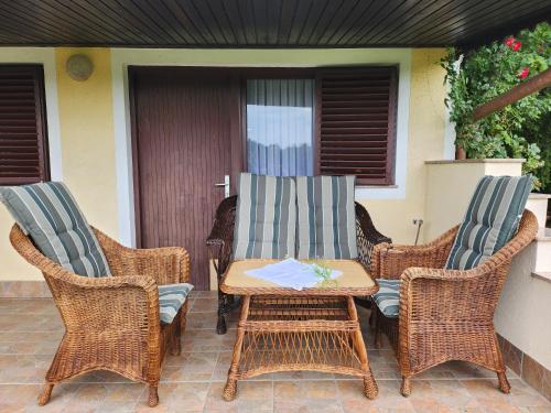 two wicker chairs and a table on a patio at Hiša Heidi in Zavrč