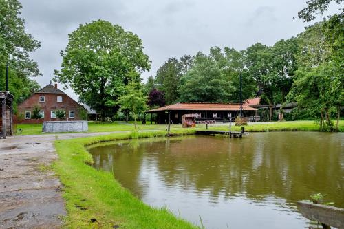 a pond in front of a building next to a house at Grodenhof in Norderschwei