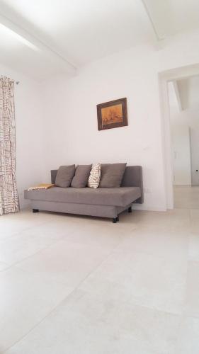 a living room with a couch in a white room at Casa Mavi in Colombaro