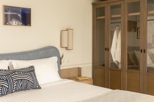 a bedroom with a bed and a glass cabinet at Homeric Poems in Fira
