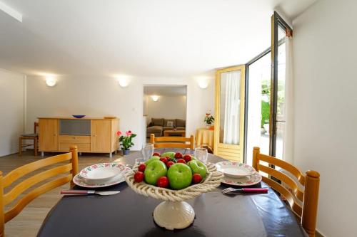 une table de salle à manger avec un bol de fruits dessus dans l'établissement Le crêt du lac charmant appartement au calme, à Sévrier