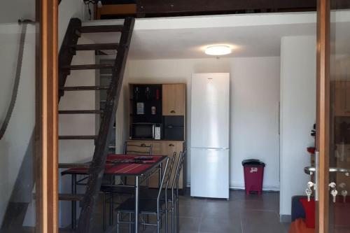 La cuisine est équipée d'une table à manger et d'un réfrigérateur. dans l'établissement Magnifique petite maisonnette climatisée avec parking privatif, au Barcarès