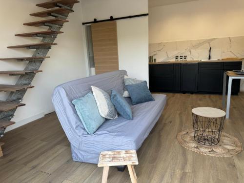 - un salon avec un canapé bleu et un escalier en colimaçon dans l'établissement Jolie maison au cœur du maquis, à Grosseto-Prugna