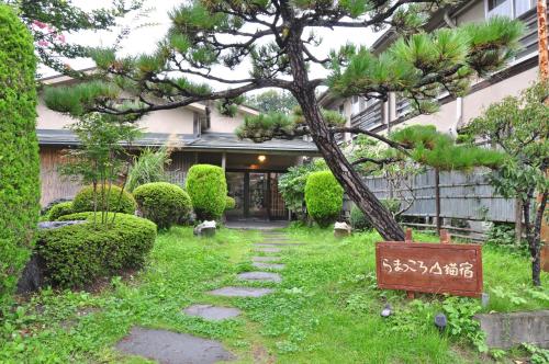 a garden with a tree in front of a building at koyado kaziya in Ichinoseki