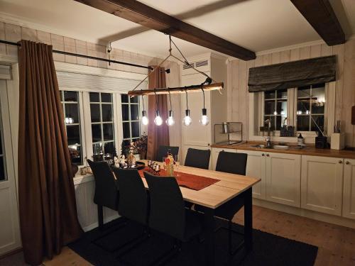 a kitchen with a wooden table and a dining room at Gaustatoppen View Apartment in Gaustablikk