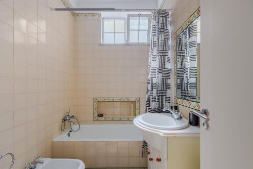 a bathroom with a sink and a tub and a toilet at Alojamento Local Coruche Erra in Coruche