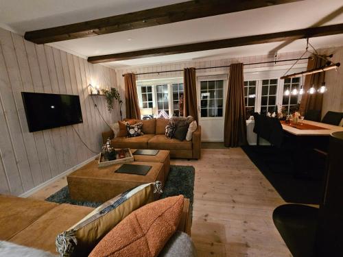 a living room with two couches and a table at Gaustatoppen View Apartment in Gaustablikk