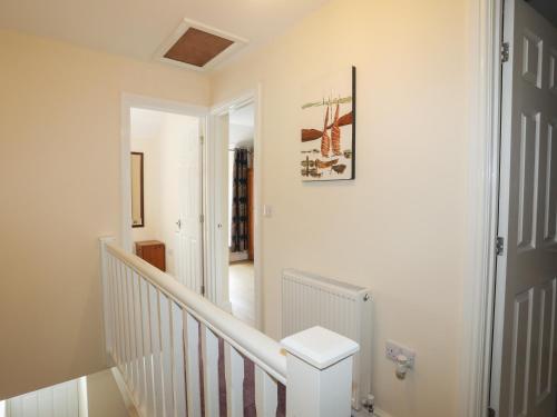 カーナーヴォンにある43 Hyfrydle Roadのトイレ付きの白い階段のある廊下