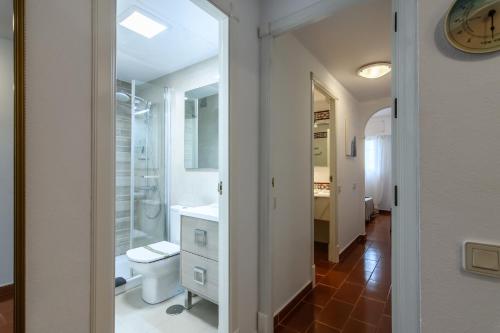 a white bathroom with a toilet and a sink at Hoyo I by Ĥ - Isla Canela Golf GHHI16B2P75 in Isla Canela