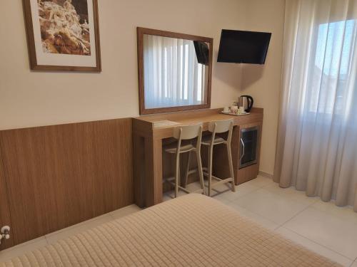 a hotel room with a vanity with a mirror and a television at Residenza La Reggia in Caserta