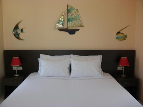sypialnia z łóżkiem z 2 lampami i oknem w obiekcie Blue Harmony Apartments w mieście Plaka