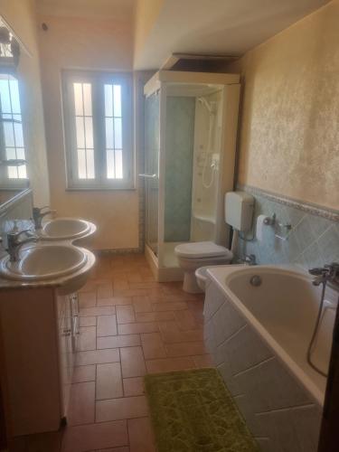 a bathroom with two sinks and a tub and a toilet at Costa di Mare in Monasterace
