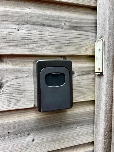 a wooden door with a tv on a wooden wall at Luxe Boshuisje met Privé Wellness & Jacuzzi op de Veluwe in Ermelo