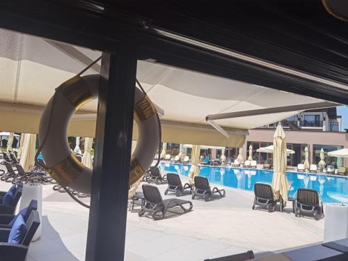 a pool with chairs and umbrellas and a swimming pool at Belchin Garden SPA&Wellness in Belchin