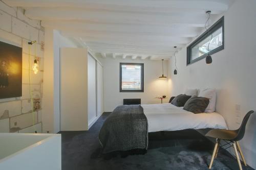 une chambre avec un grand lit et une chaise dans l'établissement Logement atypique 200m2 au Calme et Confort, à Tours