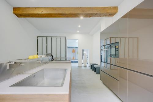 - une cuisine avec des comptoirs blancs et un grand évier dans l'établissement Logement atypique 200m2 au Calme et Confort, à Tours
